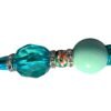 A decorative pen body featuring a large faceted teal bead, rhinestone spacer rings, a floral bead