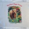 Fluffy Highland cow in colorful flowers on a white dish drying mat with text 'Big Heart Bigger Bangs'.