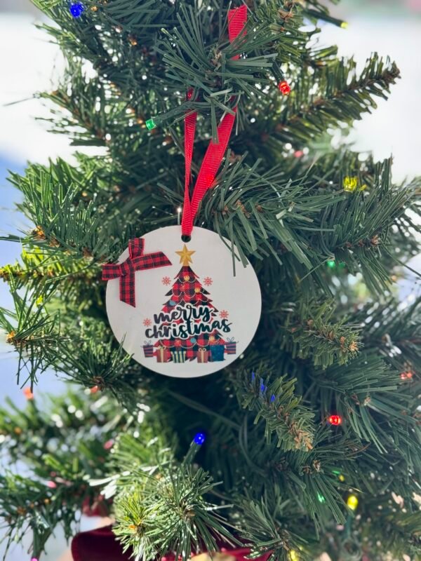 Round white Christmas ornament with a red plaid tree, gifts, and 'merry christmas' text.
