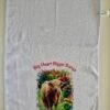White waffle-weave towel with a shaggy brown Highland cow, colorful flowers