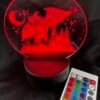 A glowing red LED night light depicting a dragon, castle, moon