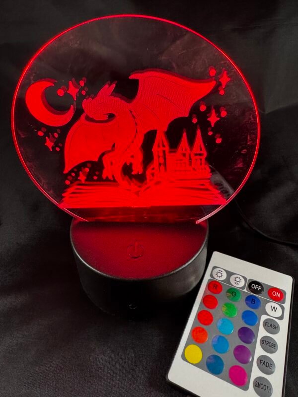 A glowing red LED night light depicting a dragon, castle, moon