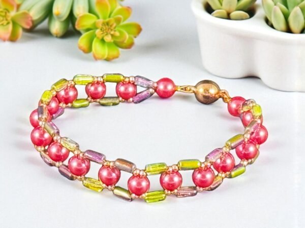 A vibrant beaded bracelet featuring coral spherical beads alternating with colorful rectangular beads.