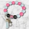 Beaded keychain: pink, blue, black, and leopard print beads, a blue tassel, and metal clasp.