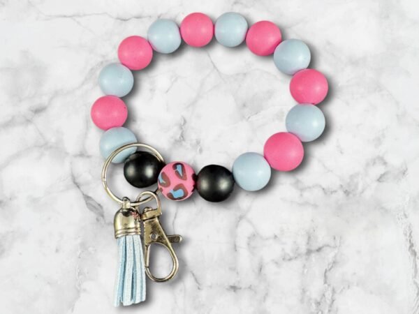 Beaded keychain: pink, blue, black, and leopard print beads, a blue tassel, and metal clasp.