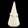Close-up of a white and gray beaded bracelet elegantly displayed on a velvety cream cone.