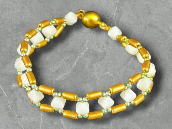 Beaded bracelet featuring white square and golden tube beads, with green spacers and a magnetic clasp.